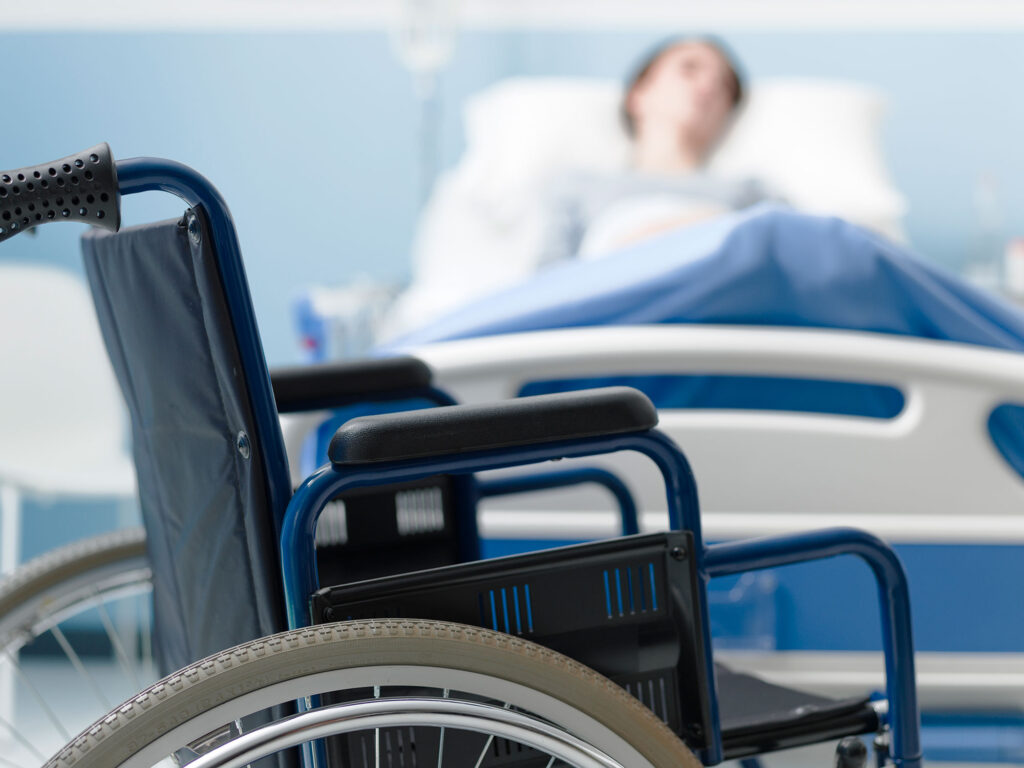 hospitalized patient with wheelchair in foreground